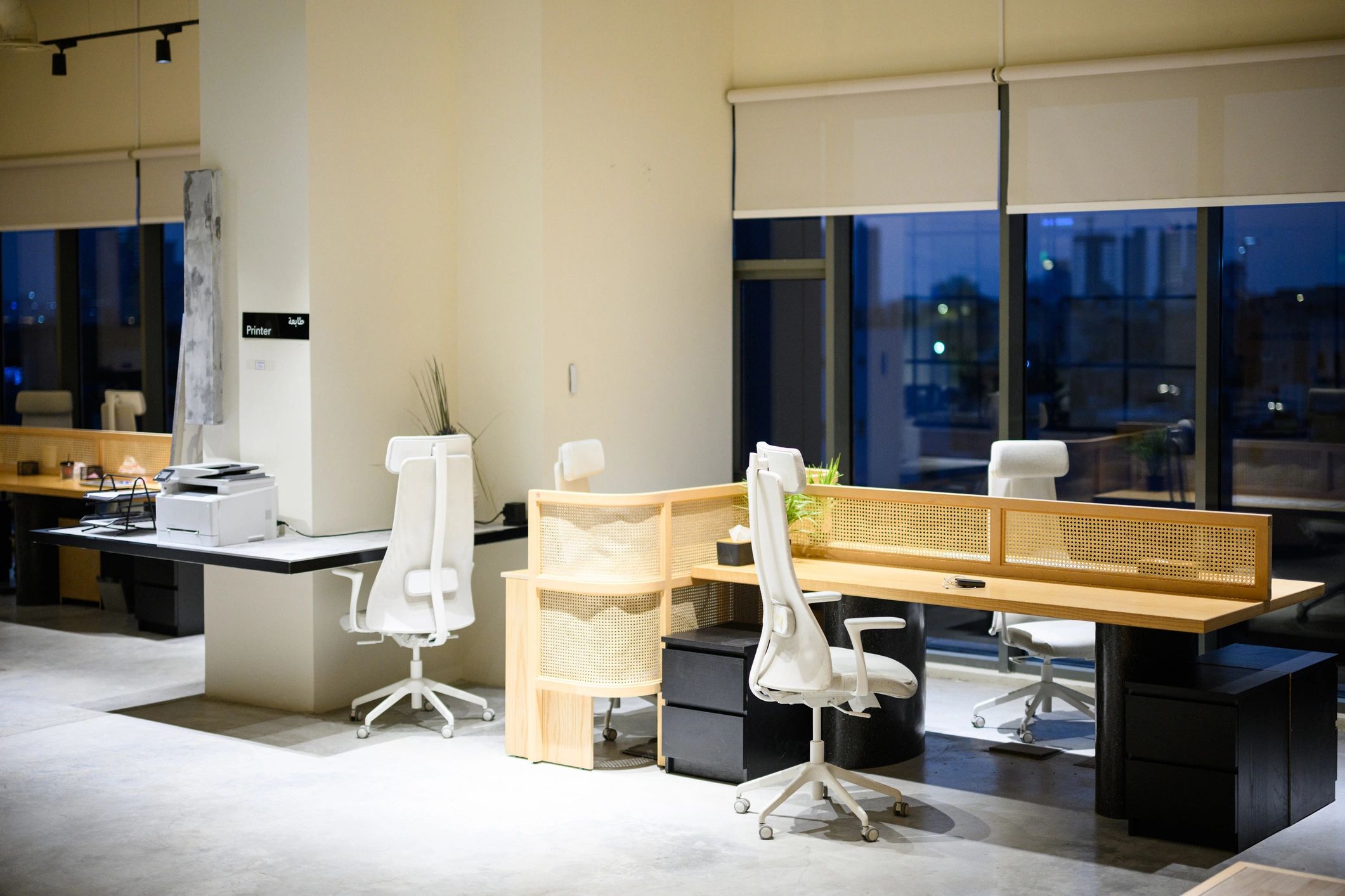 Modern office workspace with desks and laptops